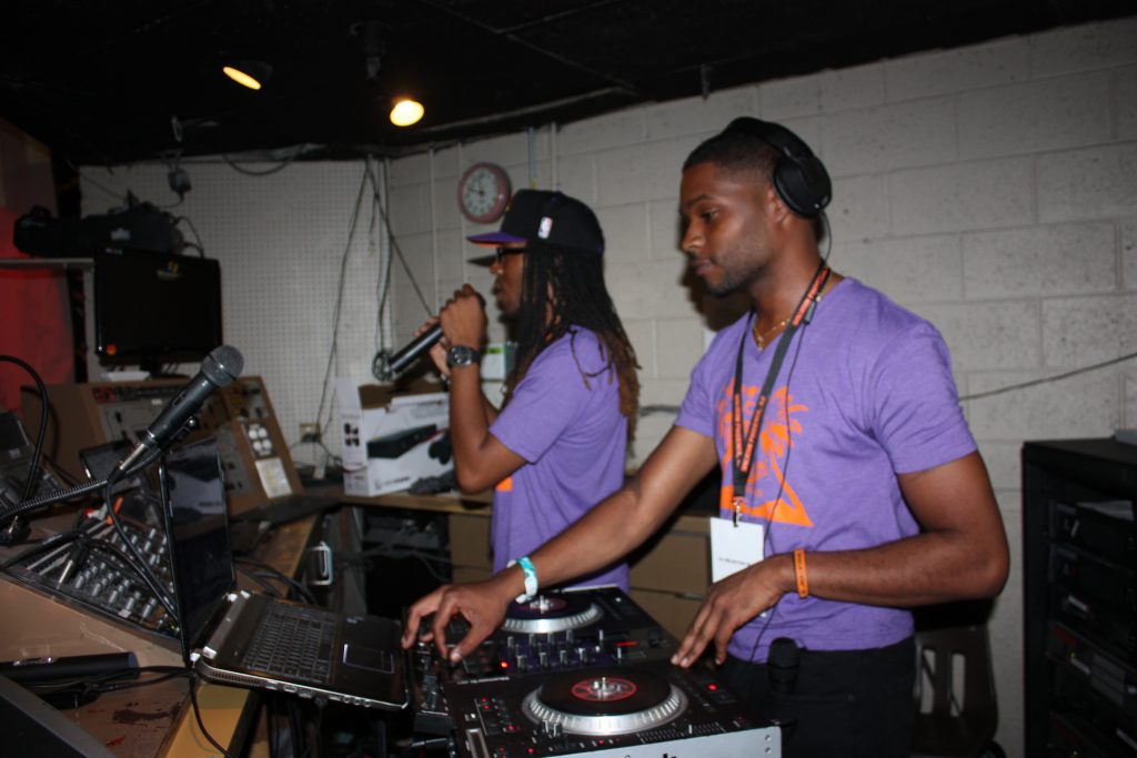 2 Male DJs in the booth at a roller rink