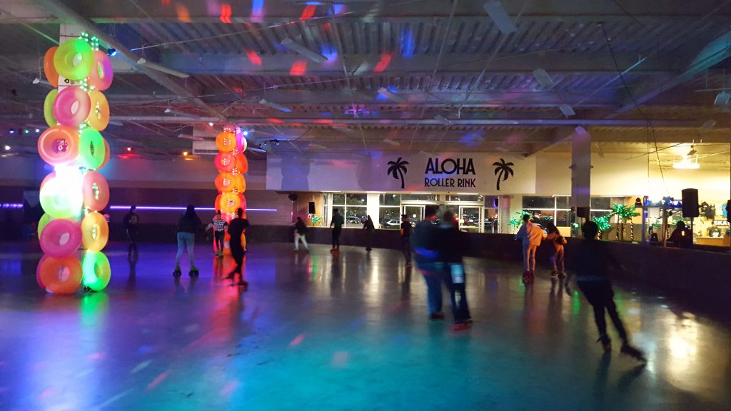 Interior shot of the Aloha Roller Rink with illuminated poles covered with brightly colored inner tubes.
