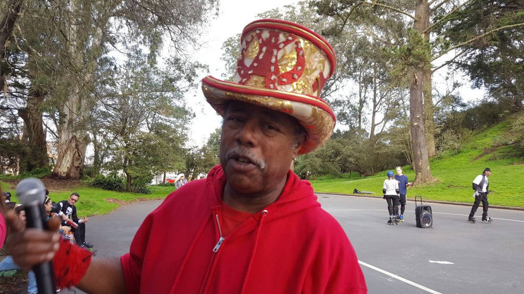 David Miles, dressed in a red hoody and a sparkly red and gold hat.