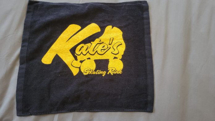 Kates Black Sweat Towel with yellow logo and a roller skate